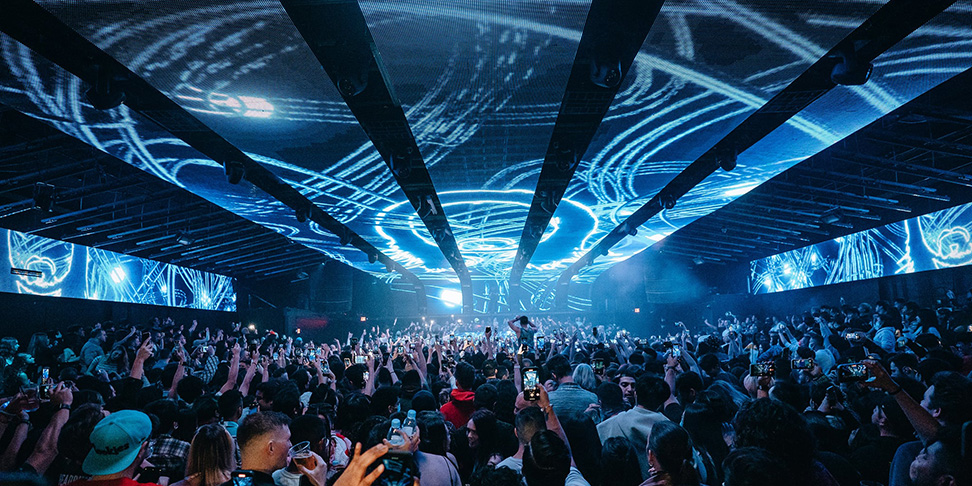 Crowd under a full ceiling LED array at an Insomniac night